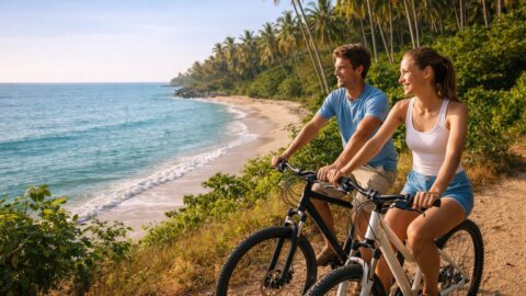 Couple Cycling Along Tropical Beach Road